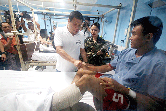 President Rodrigo Duterte visits a wounded soldier at the V. Luna General Hospital in Quezon City on Tuesday. The President has vowed to double the salaries of military personnel and the police. PHOTO BY RUY MARTINEZ