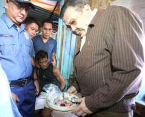 GOTCHA! Manila Mayor Joseph Estrada inspects the drug paraphernalia seized from Robert Pavillon (seated) during a clearing operation in Binondo district.  PHOTO BY BOB DUNGO 