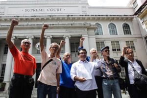 LAST RECOURSE Activists and martial law victims raise their fists after filing their petition at the Supreme Court. PHOTO BY DJ DIOSINA 