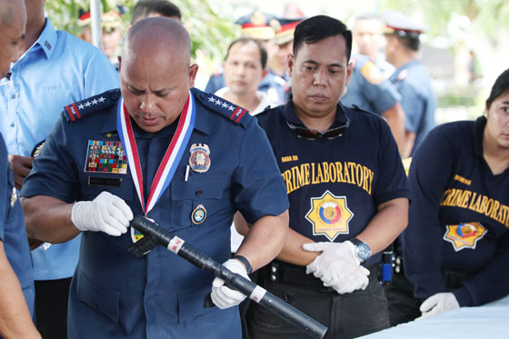 Philippine National Police chief Ronald dela Rosa tinkers with one of the firearms seized by the police under Oplan Double Barrel from June to August this year. The firearms were displayed during the 115th Police Service anniversary held at Canlubang City in Laguna. PHOTO BY RUSSELL PALMA 