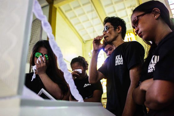 Relatives and friends of Eric Sison weep before his interment on Wednesday at the Pasay public cemetery. Sison was shot dead last week by patrolling policemen. Witnesses claimed a hail of bullets felled Sison even when he offered to surrender. Police officials are investigating the incident. PHOTO BY DJ DIOSINA 