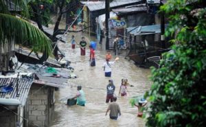 Residents wade through a flooded street in San Mateo, Rizal. Floods inundated major thoroughfares in Metro Manila because of heavy rains brought by the southwest monsoon. AFP