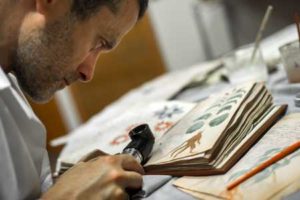 CLONED Quality control operator of the Spanish publishing outfit Siloe Luis Miguel works on cloning the illustrated codex handwritten manuscript Voynich in Burgos on August 9, 2016. The so-called Voynich Manuscript, a small unassuming book usually stored in a Yale University vault, is one of the most mysterious books in the world, that a small publishing house in northern Spain has finally secured the right to clone. AFP PHOTO