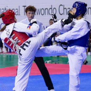 Nicole Abigail Cham (left) delivers a head kick to an opponent during a tournament. CONTRIBUTED PHOTO