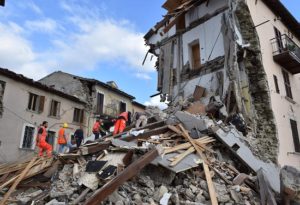 Rescuers search among damaged buildings after a strong earthquake hit central Italy, in Arquata del Tronto on Wednesday. AFP PHOTO 