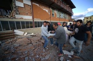 Residents and rescuers carry a victim from a damaged building after a strong earthquake hit Amatrice on Wednesday. AFP PHOTO 