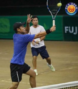 Johnny Arcilla goes for a backhand shot against Elbert Anasta and Marc Anthony Alcoseba in the finals of the 35th Philippine Columbian Assocatiaon (PCA) Open-Cebuana Lhuillier men’s doubles at the PCA indoor shell-clay court in Paco, Manila.  CONTRIBUTED PHOTO