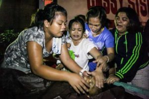 ANOTHER DEATH Family members cry in anguish over the death of a man in Pandacan, Manila on Wednesday. Police said the man was killed during a drug buy-bust operation. PHOTO BY DJ DIOSINA