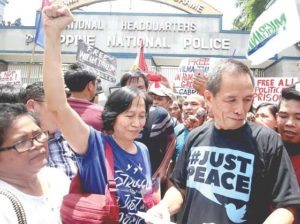 FREED COMRADES Communist rebel leaders Wilma (with raised fist) and Benito Tiamzon get out of the Camp Crame police headquarters in Quezon City after getting temporary passes from the courts. The two, who will join the resumption of peace talks with the government in Oslo, Norway next week, was welcomed by militant groups. PHOTO BY MIKE DE JUAN