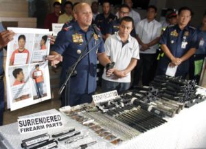 GUN SMUGGLERS? Philippine National Police chief Ronald de la Rosa (left) and Chief Supt. Roel Obusan (right), head of the Criminal Investigation and Detection Group, present Wilford Palma (center), member of an alleged group of gun smugglers said to have been tapped to supply firearms for a plot to assassinate the President. Authorities also showed to the media gun parts seized from the group. PHOTO BY MIKE DE JUAN 
