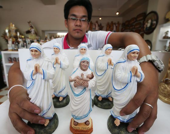 A man displays images of Blessed Teresa of Calcutta at a religious store in Tondo, Manila. Mother Teresa, who served the destitute through her Missionaries of Charity, will be canonized on September 4. PHOTO BY RENE DILA