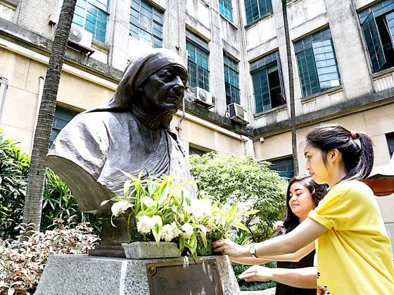  Students offer flowers before the bust of Mother Teresa at the University of Santo Tomas Central Seminary in Manila. The Albanian religious sister will be canonized today by Pope Francis at the Vatican. PHOTO BY RENE DILAN