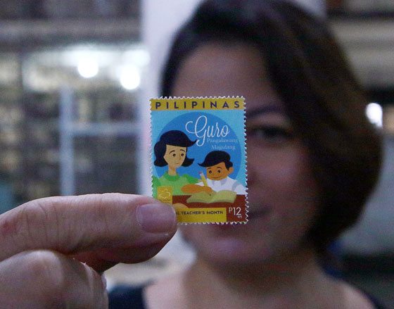 Aileen Bernardo, an employee of the Philippine Postal Corp., holds a special stamp issued to honor teachers as the country celebrates National Teachers’ Month. PHOTO BY BOB DUNGO 