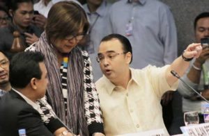 Sen. Leila de Lima (center) standing between feuding colleagues Antonio Trillanes 4th (left) and Alan Peter Cayetano (right) during the Senate probe into summary killings on Thursday.