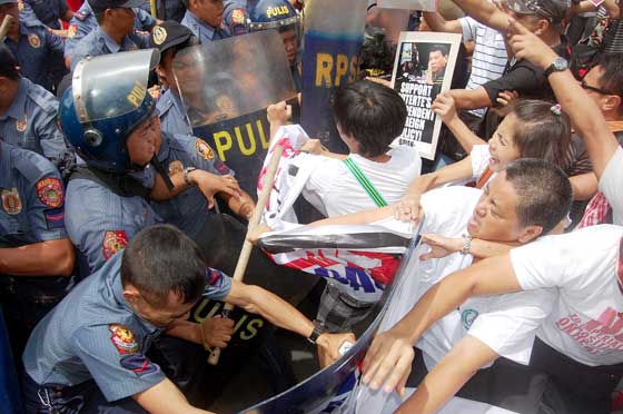  Police try to prevent members of militant groups from  holding a protest action in front of the US Embassy on Roxas Boulevard in Manila on Friday. The day marked the 25th anniversary of the rejection by the Philippine Senate of the continued stay of US military bases in the country.  PHOTO BY ROGER RAÑADA