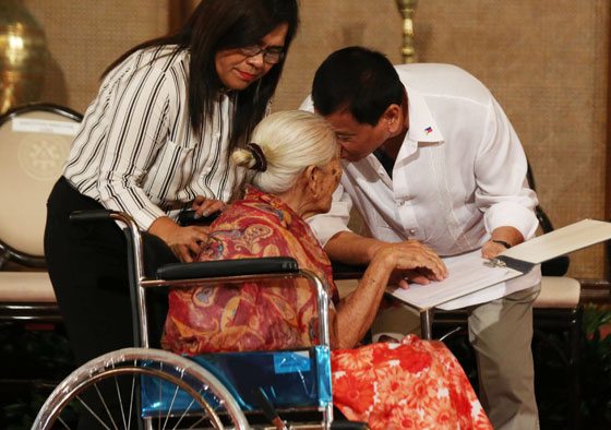 President Rodrigo Duterte (right) kisses the forehead of 108-year-old Lourdes Marquez in ceremonies for the signing of rules implementing the Centenarians Act of 2016 at Malacañang’s Rizal Hall. The law grants a cash gift of P100,000 to persons who reach the century mark.  PHOTO BY RENE H. DILAN 