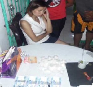 EVIDENCE Toni Ann Abutin Alcala being investigated at the police station with the sachets of shabu and marked money (foreground) confiscated during her arrest. CONTRIBUTED PHOTO