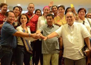 President Rodrigo Duterte joins hands with Environment Secretary Gina Lopez (2nd from left), Agriculture Secretary Emmanuel Piñol (left) and Presidential Spokesperson Ernie Abella (right) to signify mutually supportive efforts to uplift the lives of the Filipino poor during the Mindanao Environment Summit (Oya Mindanaw) held at the Ateneo de Davao University. Joining them are representatives of civil society organizations.