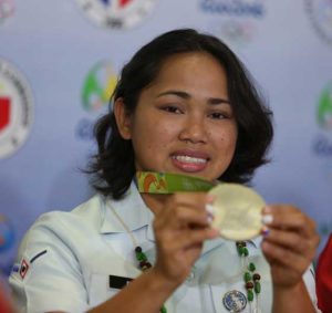 Weightlifter Hidilyn Diaz hoists the silver medal she won in the 2016 Rio Olympics.  PHOTO BY RUSSEL PALMA 