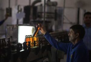 FORBIDDEN BREW This file photo shows a Pakistani worker scanning filled whisky bottles as they pass before an illumination panel at the Muree Brewery Company in Rawalpindi. Whether it’s beer produced by the crateful in a venerable red brick brewery, or wine discreetly fermented in a bedroom, alcohol sales are booming in Pakistan—despite being banned for 97 percent of the population. AFP PHOTO