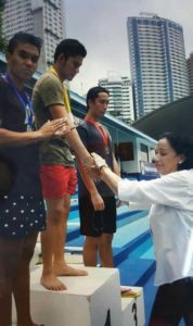 Federation of School Sports Association of the Philippines Vice President Tisha Abundo leads the awarding of medals to the winners of the men’s 200m freestyle including gold medalist National University standout Martin Jacob Pupos (center). CONTRIBUTED PHOTO