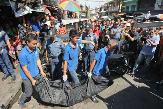 Employees of a funeral parlor carry the dead body of one of three suspects killed in a buy-bust in Santa Cruz, Manila. The Station Anti-Illegal Drugs-Special Operation Task Unit of Plaza Miranda Police Community Precinct conducted the buy-bust on Jayar Pamelan, who was with Allan Salon and a person named Dodong. Police recovered a .45 caliber revolver, a .357 magnum, white crystalline substance suspected to be shabu, and drug paraphernalia. PHOTO BY BOB DUNGO JR.