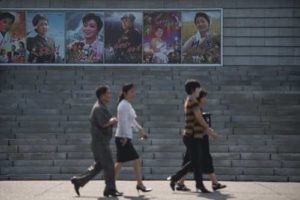 People walk past film posters as they arrive to watch a film at the Pyongyang International Cinema during the 15th Pyongyang Film Festival in the capital of North Korea on Saturday. AFP PHOTO