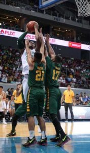 Ben Mbala of DLSU scores through the defense of Richard Escoto and Prince Orizu of FEU during a UAAP basketball game held at the Mall of Asia Arena in Pasay City on Wednesday. PHOTO BY RUSSELL PALMA