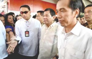 ‘BROTHERS’ Indonesian President Joko Widodo (right) and Philippine President Rodrigo Duterte (center) visit Tanah Abang market in Jakarta on September 9. Duterte was in Indonesia for a working visit after joining the Association of Southeast Asian Nations summits in Laos, his first international engagement. AFP PHOTO BY BAY ISMOYO