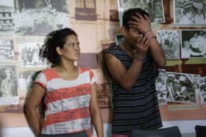 Marcos Castañeda covers his face as he and his wife were presented to the media Friday. PHOTO BY RUSSELL P