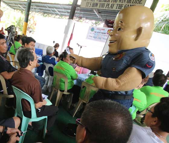 “Bato,” the mascot of the Philippine National Police headed by Director General Ronald “Bato” dela Rosa, distributes leaflets to Filinvest II residents on Batasan Hills in Quezon City on Sunday during a briefing on Double Barrel/Oplan Tokhang with Senior Supt. Guillrmo Lorenzo Eleazar, Quezon City Police District director, in line with the government’s crackdown on illegal drugs. PHOTO BY RUY L. MARTINEZ