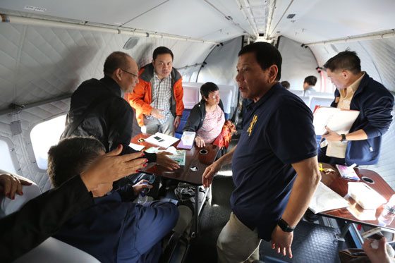 President Rodrigo Duterte (second right) and some of his Cabinet members are shown holding a meeting on board a Philippine Air Force plane going to Batanes on October 14. MALACAÑANG PHOTO