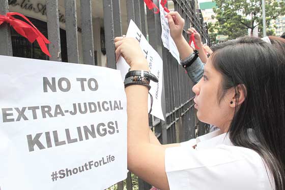  Students from St. Paul University post placards in front of their school during a rally to condemn extrajudicial killings. PHOTO BY ROGER RAÑADA 