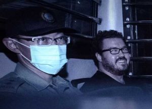 This file photo taken on November 10, 2014 shows Rurik Jutting (R) smiling as he sits in a prison van leaving the eastern court in Hong Kong. AFP PHOTO