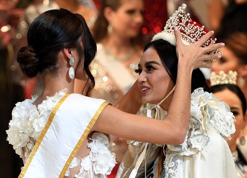 Newly elected 2016 Miss International Kylie Verzosa from Philippines (R) is helped by 2015 Miss International Edymar Martinez from Venezuela (L) during the Miss International beauty pageant final in Tokyo on Thursday. AFP PHOTO