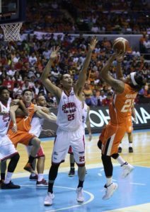 Reynel Hugnatan of Meralco shoots through the guard of Japeth Aguilar of Ginebra during Game 2 of the PBA Governor’s Cup best-of-seven finals at the Araneta Coliseum on Sunday. PHOTO BY RUSSELL PALMA