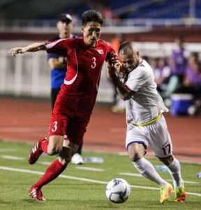 Jang Kuk Chol of North Korea (left) and Stephan Schrock of the Philippines battle for the ball during an international friendly match at the Rizal Memorial Football Stadium in Manila on Monday. PHOTO BY DJ DIOSINA