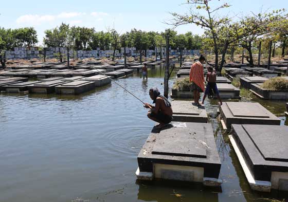 A local casts his fishing rod while stationed atop a tomb at the flooded public cemetery in Macabebe, Pampanga. Flooding brought by heavy rains from typhoons Karen and Lawin could pose a problem for cemetery visitors ahead of the commemoration of All Saints’ Day and All Souls’ Day. PHOTO BY MIKE DE JUAN