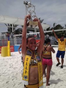 University of Santo Tomas’ Cherry Ann Rondina raises her University Athletic Association of the Philippines Season 79 beach volleyball tournament Most Valuable Player trophy in the women’s division.  CONTriBUTED PHOTO