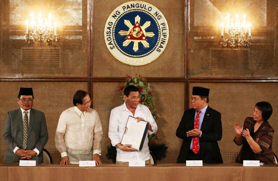 MORE INCLUSIVE BODY President Rodrigo Duterte holds a copy of the Executive Order on the Bangsamoro Transition Commission which he signed in the presence of (from left) MILF chief negotiator Mohagher Iqbal, presidential adviser Jesus Dureza, MILF chairman Al Hajj Murad and government peace panel chairman Irene Santiago. PHOTO BY RENE H. DILAN 