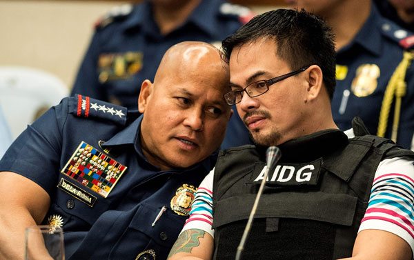 Philippine National Police (PNP) chief Director General Ronald dela Rosa (L) talks to Kerwin Espinosa (R), son of the late mayor Rolando Espinosa during the Senate drug hearing at the Senate building in Manila./ AFP / NOEL CELIS