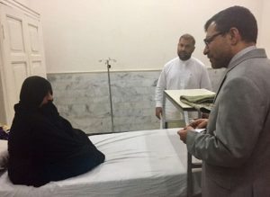 Afghan Consul General in Peshawar Abdul Waheed Poyan (R) talks with Afghan woman Sharbat Gula, known internationally as the 'Afghan Girl' who appeared on the cover of a 1985 edition of National Geographic magazine, during his visit to a hospital in Peshawar on November 2, 2016. A Pakistani court refused bail November 2 to an Afghan woman immortalised on a National Geographic cover after she was arrested in Pakistan and accused of being one of thousands of refugees using fake ID cards. / AFP PHOTO / A MAJEED