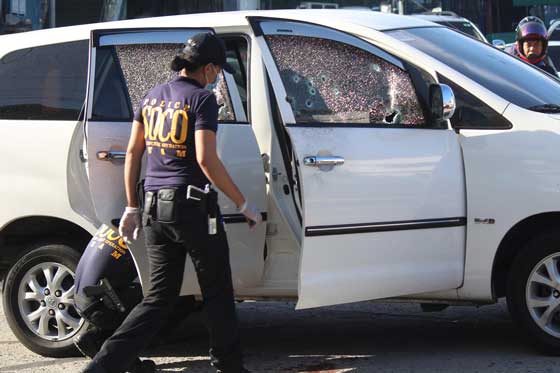 DEATH AT DAWN Investigators go through the bullet-riddled vehicle of BIR Director Jonas Amora, who was killed by unidentified assailants in Quezon City early Monday. Investigators have yet to establish the motive of the killing. PHOTO BY RUY L. MARTINEZ