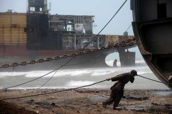 ShIP DEMOLITION AT RECORD LEVELS A Pakistani shipyard worker pulls on a wire attached to a motor that will help peel away part of the outer structure of a beached vessel being dismantled in one of the 127 ship-breaking plots in Gaddani, Pakistan. Maritime association bimco said that more than 500,000 TEUs (twenty-foot equivalent units) of capacity have been scrapped so far in 2016, a record pace that is helping to reduce the shipping industry’s overcapacity. AFP PhOTO