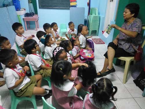 ‘KIDS OF READERS’ Tita Marie captures not only the attention, but also the hearts of the day care toddlers in her weekly story telling session in Barangay Tambak, Pagbilao, Quezon. PHOTO BY BELLY M. OTORDOZ