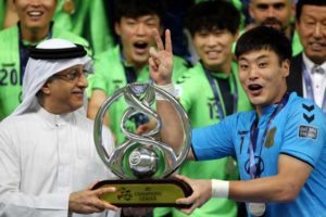 A Jeonbuk Hyundai Motors player receives the trophy after winning the the Asian Champions League. AFP PHOTO