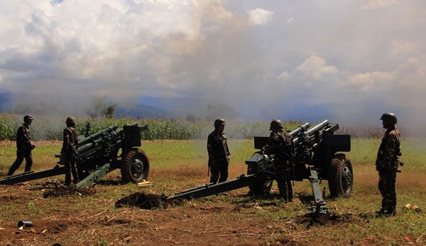 Philippine troops fire their 105mm howitzer cannons towards enemy positions from their base near Butig town in Lanao del Sur province on the southern island of Mindana . AFP Photo