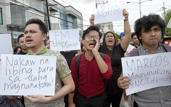 BACK TO THE STREETS Anti-Marcos protesters shout slogans in front of the gates of the Libingan ng mga Bayani in Taguig while the late strongman Ferdinand Marcos was being given a hero’s burial. AFP PHOTO BY TED ALJIBE 