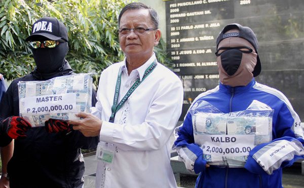 INSTANT MILLIONAIRES Philippine Drug Enforcement Agency chief Isidro Lapeña hands P2 million cash each to two drug tipsters. PHOTO BY MIKE DE JUAN 