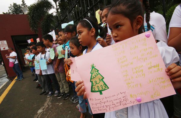 Members of Child Rights Network hold huge Christmas cards and sing carols outside the House of Representatives as they join a lobby urging lawmakers not to lower the age of criminal responsibility from 15 to nine. PHOTO BY RUY L. MARTINEZ
